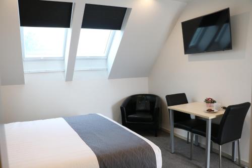 a bedroom with a bed and a table and a tv at MCM Motel Christchurch in Christchurch