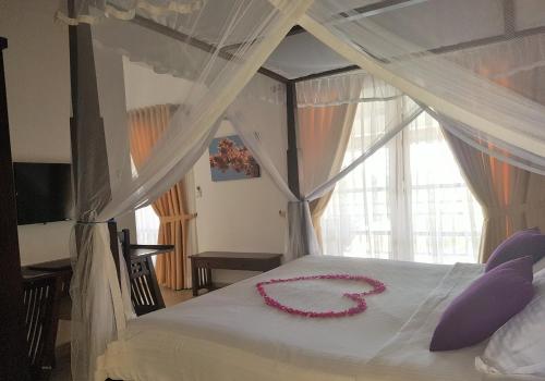 a bedroom with a bed with a necklace on it at IMAGINE Villa Hotel in Mirissa