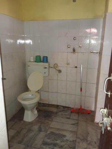 een badkamer met een toilet en een dweil bij Singh Guest House in Varanasi