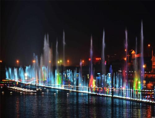 a city with a fountain in the water at night at Shangri-La Huhhot in Hohhot