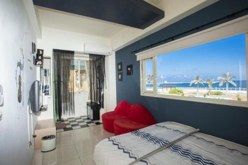 花蓮市的住宿－陽光海岸海景民宿，一间卧室设有一张床和一个享有海景的窗户。