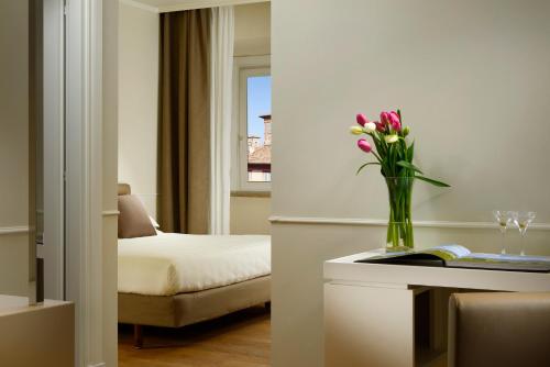 a hotel room with a vase of flowers on a table at Locanda della Posta Boutique Hotel in Perugia