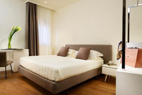 a bedroom with a large white bed in a room at Locanda della Posta Boutique Hotel in Perugia