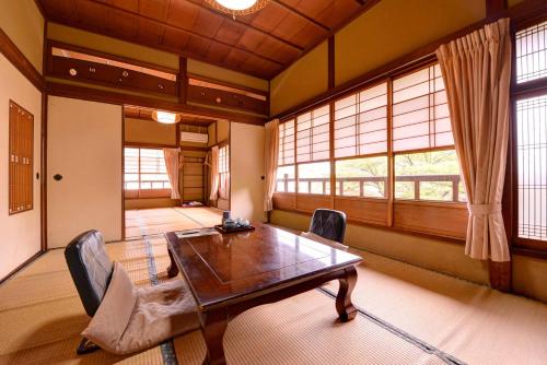 a dining room with a wooden table and two chairs at Bingoya in Kurashiki