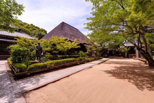 a path in a park with a statue in front of a building at Bingoya in Kurashiki