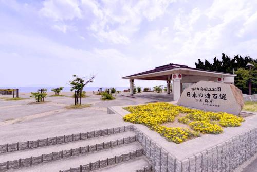 a monument with yellow flowers next to the ocean at Bingoya in Kurashiki