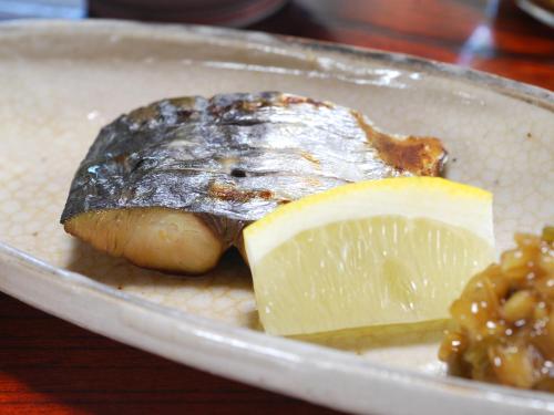 a plate of food with a piece of cheese and a lemon at Bingoya in Kurashiki