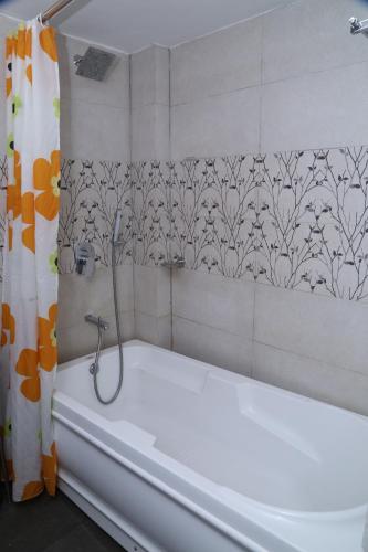 a bathroom with a bath tub with a shower curtain at Terrace Gardens in Bangalore