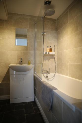 a bathroom with a tub and a sink and a shower at Holiday Home Elerkin in Durham