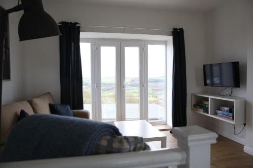 a living room with a couch and a large window at Holiday Home Elerkin in Durham