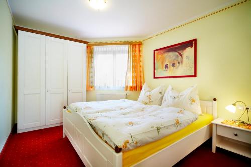 a small bedroom with a white bed and a window at Appartements Castello in Königsleiten