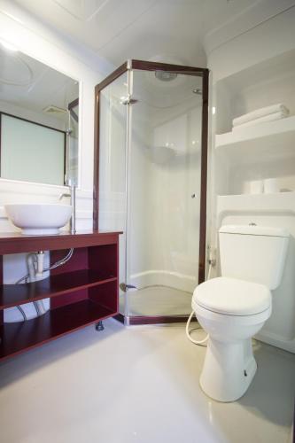 a bathroom with a toilet and a shower and a sink at Mars City Hotel in Denpasar
