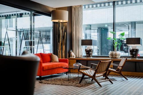 a living room with a red couch and chairs at Hotel F6 in Helsinki
