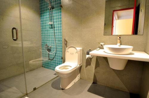 a bathroom with a toilet and a sink and a shower at Ivy Lane Colombo in Colombo