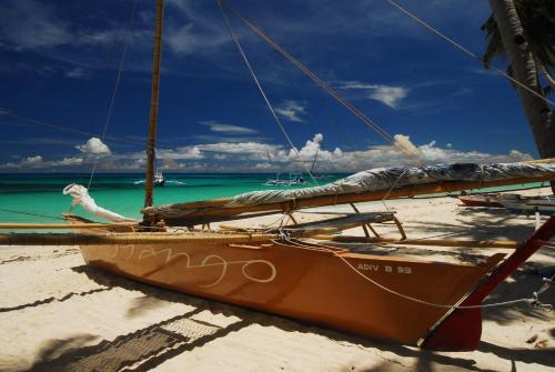 a boat sitting on the sand on a beach at Levantin Boracay in Boracay