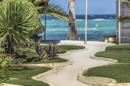 a walkway near the beach with palm trees and the ocean at Levantin Boracay in Boracay