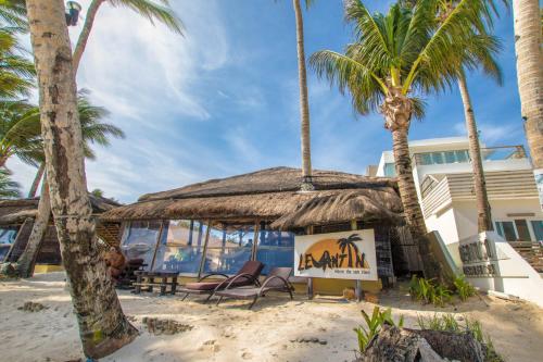 a restaurant on the beach with palm trees at Levantin Boracay in Boracay