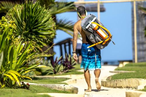 
a man walking down the street holding a surfboard at Levantin Boracay in Boracay
