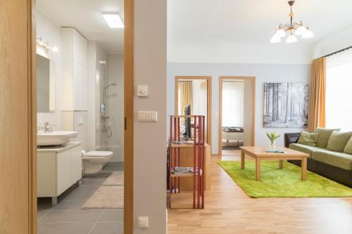 a bathroom and a living room with a couch and a table at Saaresalu City Center Apartment in Pärnu