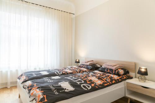 a bedroom with a bed with a comforter on it at Saaresalu City Center Apartment in Pärnu
