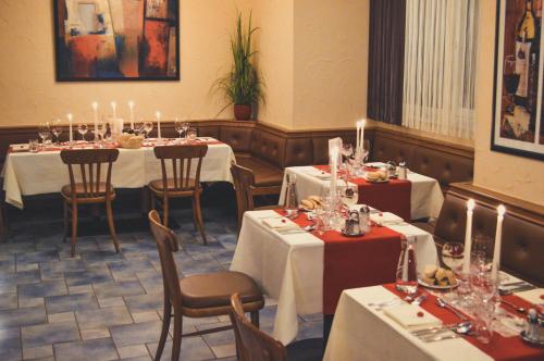 ein Esszimmer mit Tischen und Stühlen mit Kerzen in der Unterkunft Hotel & Tennis Riederhof in Mantscha
