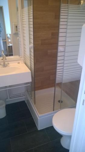 a bathroom with a shower and a toilet and a sink at Fasthotel Chateauroux in Déols