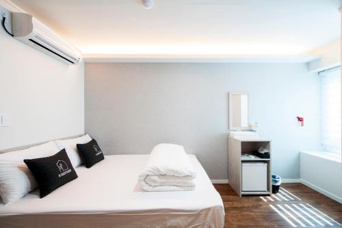 a small bedroom with a white bed and a window at Seoul Grand Hostel EWHA Univ in Seoul