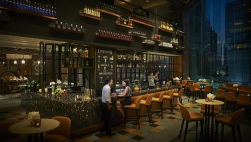 two people standing at a bar in a restaurant at Amari Bangkok in Bangkok