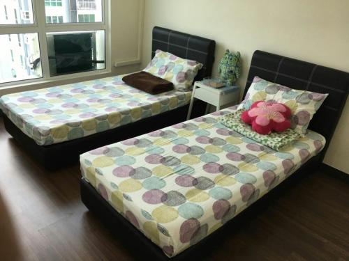 two beds sitting in a room with at Sandakan Spacious and Comfortable Pool View Condo in Sandakan
