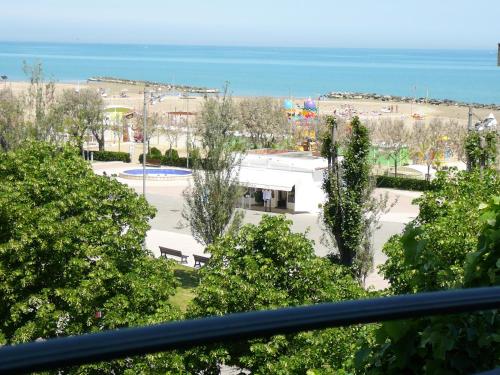 a view of a park with trees and the ocean at Hotel De La Plage in Rimini