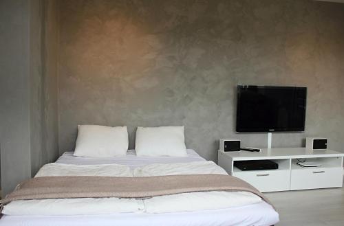 Schlafzimmer mit einem Bett und einem Flachbild-TV in der Unterkunft City View Studio Apartment in Ålesund