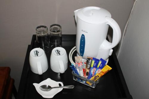 a table with a tea pot and a blender at Fin and Feather Guest Lodge in Boksburg