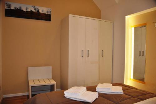 a bedroom with a bed and a cabinet and a chair at San Guglielmo Apartments in Ferrara