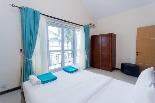 a bedroom with two beds and a large window at Garden Villas in Grand-Baie