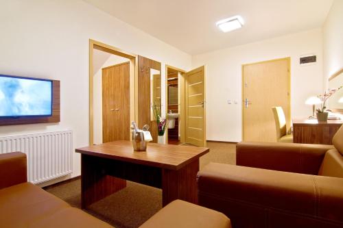 a living room with a couch and a table at Dolina Leśnicy SKI & SPA Resort in Brenna