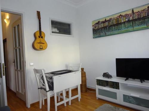 a room with a desk and a guitar on the wall at Bom dia Porto in Vila Nova de Gaia