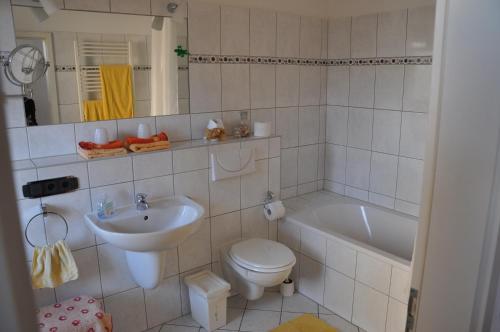 ein Badezimmer mit einem Waschbecken, einem WC und einer Badewanne in der Unterkunft Martina`s Gästezimmer in Erfurt