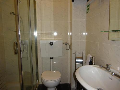 a bathroom with a toilet and a shower and a sink at Bom dia Porto in Vila Nova de Gaia
