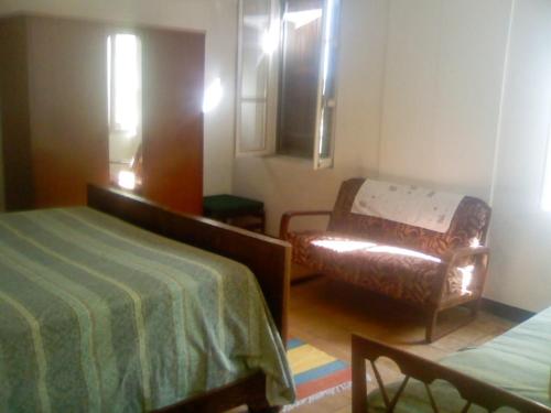 a room with a bed and a couch and a chair at Agriturismo Antica Golena in Guastalla