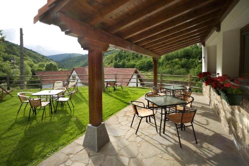 a patio with tables and chairs on the grass at Hotel Rural Besaro - Selva de Irati in Izalzu