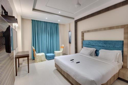 a bedroom with a large bed and a television at Red Carlton in Kānpur