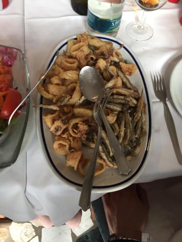 a plate of food with utensils on a table at Albergo Ristorante La Greppia in Montedivalli Chiesa