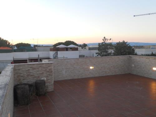 un gran patio con una pared de ladrillo y una puesta de sol en Manfredonia - Ippocampo Seaside Home, en Ippocampo