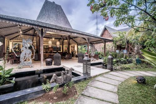 a house with a statue in front of it at Wayang Retreat in Canggu