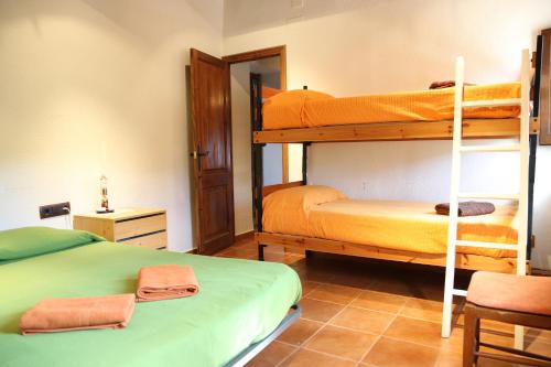 a room with two bunk beds and a chair at Cal Vidal in Mura