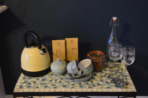 a table with a tea kettle and glasses on it at Briar Brae Bed & Breakfast in Stranraer