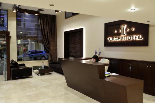a woman sitting at a reception desk in a hotel lobby at Europa Hotel in Kastoria