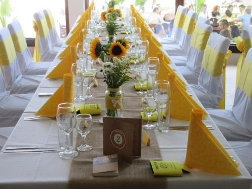 een lange tafel met gele en witte tafels met glazen bij Saint George Hotel 1 in Balchik