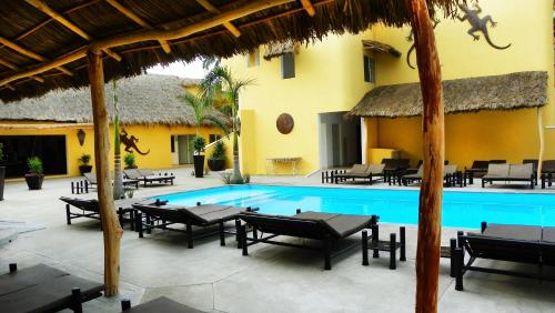 a resort with a swimming pool with tables and chairs at Zar Manzanillo in Manzanillo