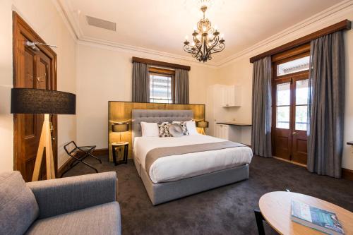 a hotel room with a bed and a couch at The Parkview Hotel Mudgee in Mudgee
